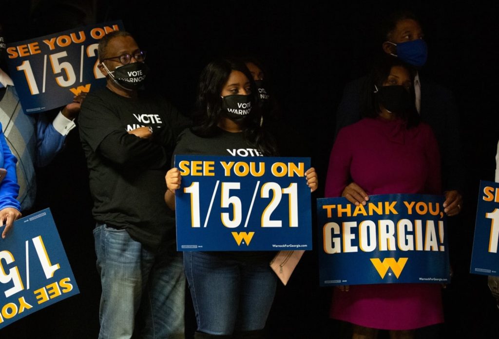 Supporters of the Warnock campaign hold signs during an Election Night event on November 3 in Atlanta. 